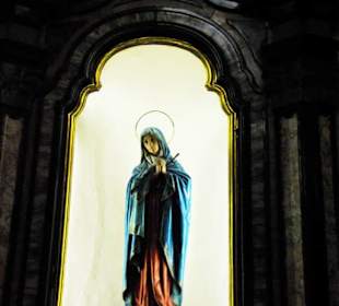 Viele Heiligenfiguren hinter Glas