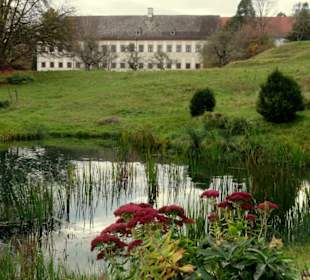 Blick über einen Teich auf das Kloster
