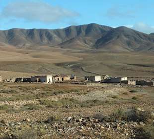 Reste alter Steinhäuser vor imposanter Landschaft