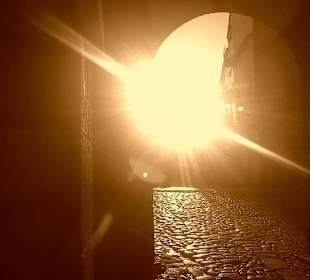 Durch den Stadttorbogen in den Sonnenuntergang