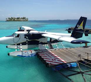 Jetty mit Flugzeug und privater Insel im Hintergrund