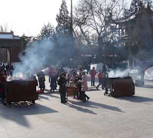 Gläubige entzünden Räucherstäbchen