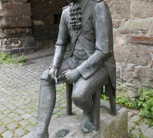 Er sitzt vor dem Marschiertor