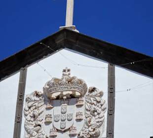 Kreuz und Stadtwappen am Giebel der Kirche