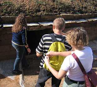 Besucher und Führerin vor dem Tumulus-Eingang