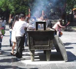 Gläubige Buddhisten zünden ihre Räucherkerzen an