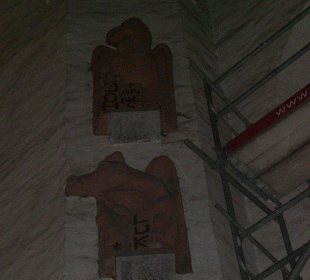 Holzfiguren in der Wand der Kirche.