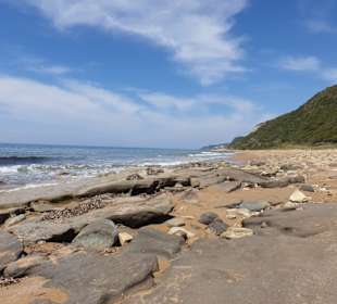 Strand mit Felsen und Sand
