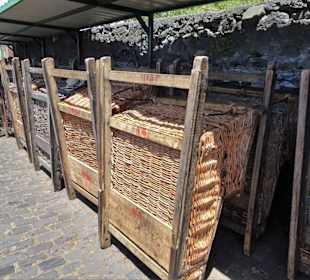 Gestapelte Korbschlitten am Berg