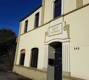 An diesem Gebäude links rein und über den Kanal