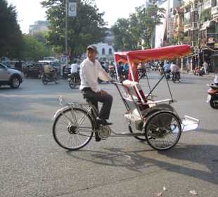 Ein Rikschafahrer im Straßengewimmel.