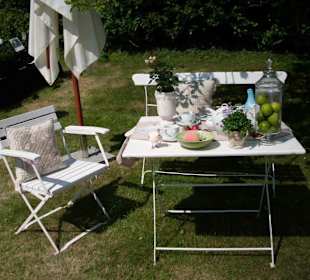 Gartendekorationen auf Tisch und Bank