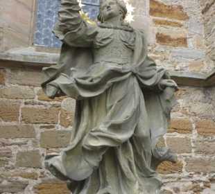 An / vor der Außenmauer der Gerolzhöfer Kirche