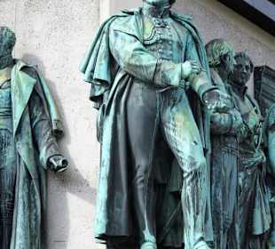 Die Persönlichkeiten am Sockel des Denkmales