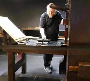 Ein Drucker schwärzt die Platte