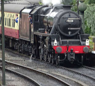 Der Dampflokzug fährt in den Bahnhof ein