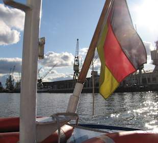 Barkassenheck im Gegenlicht vor Hafenkulisse