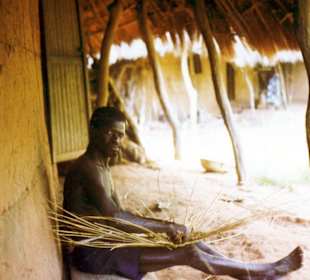 Ein Dorfeinwohner beim Körberflechten