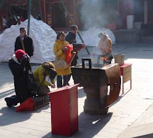 Gläubige entzünden Räucherstäbchen
