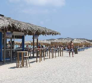 Bar und Sonnenschirme mit Liegen am Strand