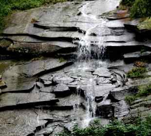 Wasser fließt über kreisrundes Gestein
