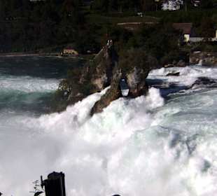 Besucher auf dem Fels mitten im Wasserfall