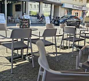 Tische unter Sonnenschirmen