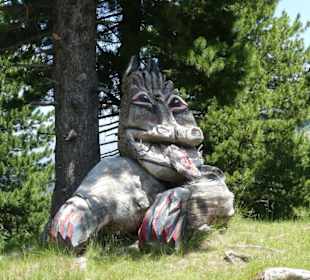 Wurzelschnitzerei am Fahrbahnrand