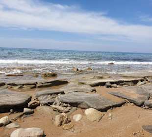 Strand mit Felsen und Sand