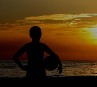 Ballspiel am Strand bei Sonnenuntergang
