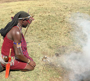 Ein Masai beim Feuer machen