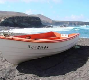 Boot am schwarzen Strand