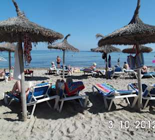 Strand mit Liegen und Sonnenschutz