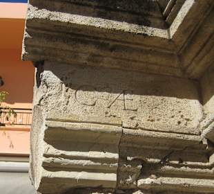 Die Inschrift links oben am Brunnen