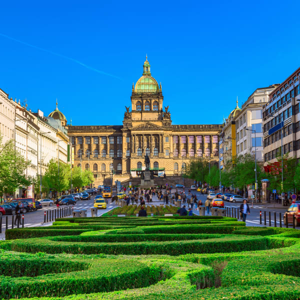 Ein großer Platz mit Grünanlagen und einem stattlichen neoklassischen Gebäude am Ende