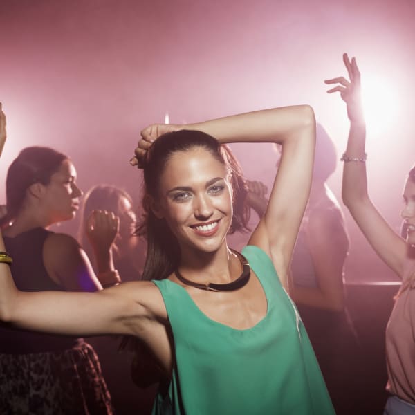 Eine junge Frau tanzt ausgelassen in einem Club. © Morsa Images/Stone via Getty Images