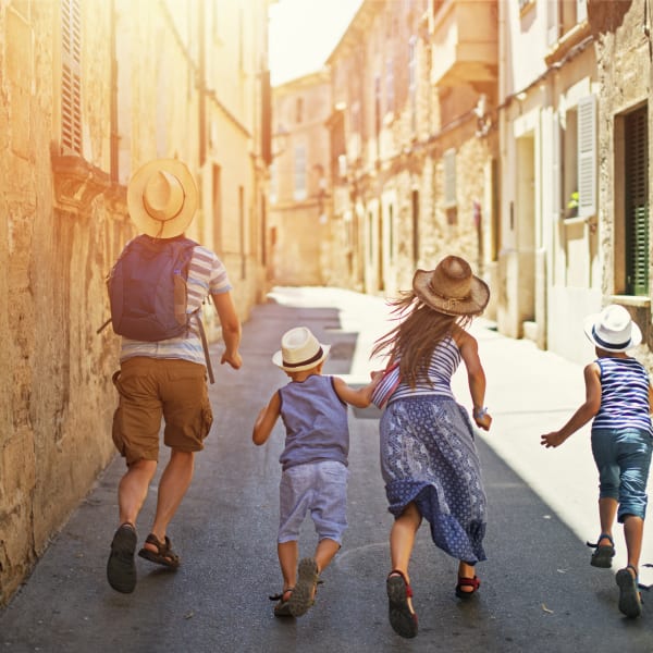 Familie mit zwei Kindern rennt durch die Altstadt von Mallorca © iStock.com/Imgorthand