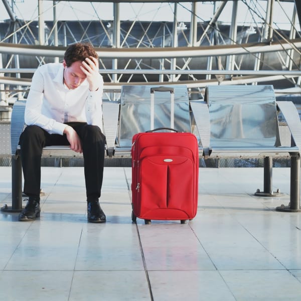 Wegen Flugverspätung oder Problem auf dem Flughafen wartet ein müder Passagier am Terminal ©iStock.com/anyaberkut