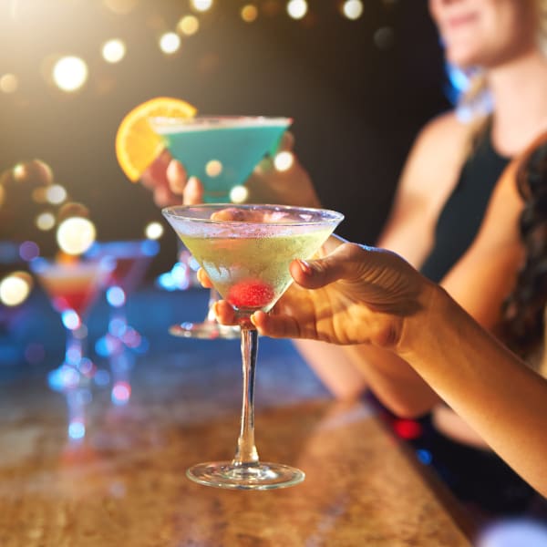 Frauen trinken bunte Cocktails in einem Nachtclub. © gradyreese/iStock / Getty Images Plus via Getty Images