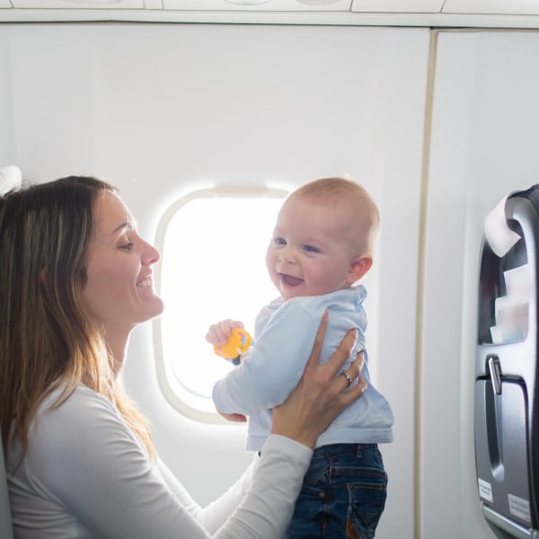 Junge Mutter spielt mit ihrem Kleinkind im Flugzeug ©tatyana_tomsickova/iStock