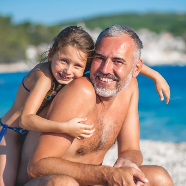 Vater mit seiner Tochter beim Strandurlaub ©CasarsaGuru/iStock