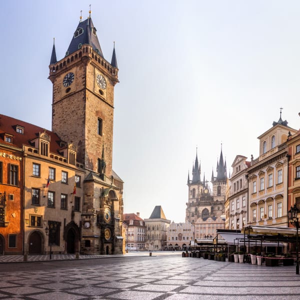 Ein Platz mit alten Gebäuden und einem viereckigen, mittelalterlichen Turm mit einer Uhr