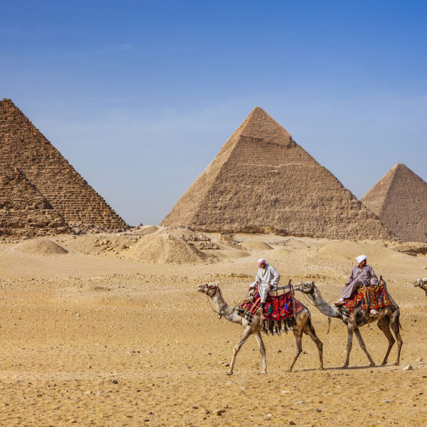 Beduinen auf Kamelen vor den Pyramiden von Gizeh, Ägypten