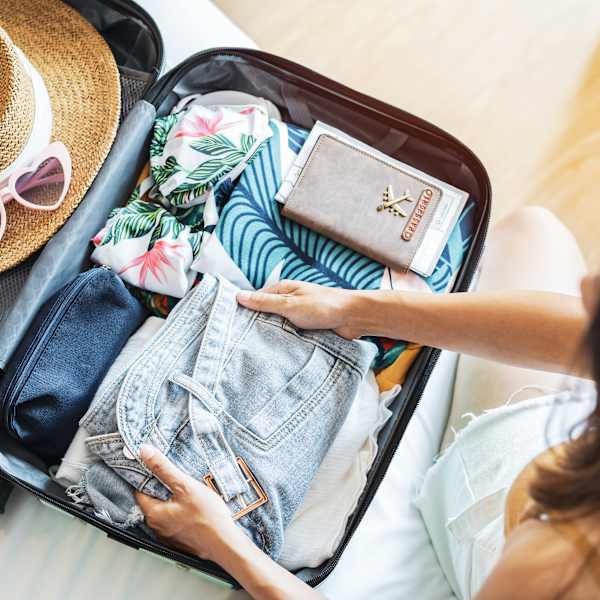 Eine Frau packt einen Koffer.
