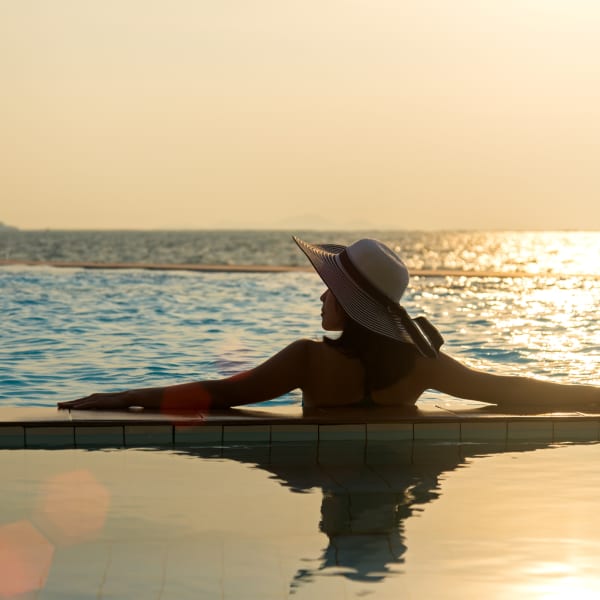 Eine Frau bei Sonnenuntergang in einem Pool.