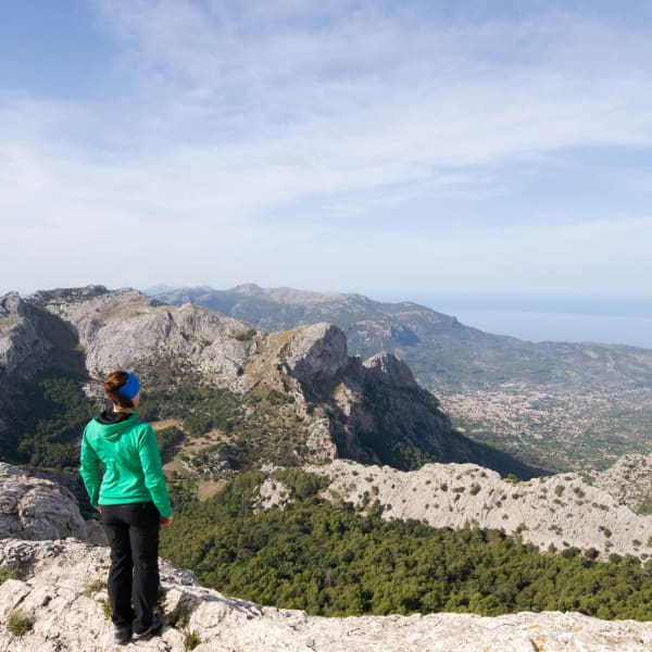 Eine Frau steht auf einem beg und blickt auf das Meer auf Mallorca.