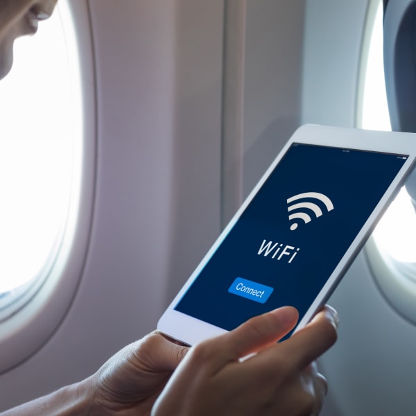 Ein Tablet wird mit dem Wlan auf einem Flugzeug verbunden