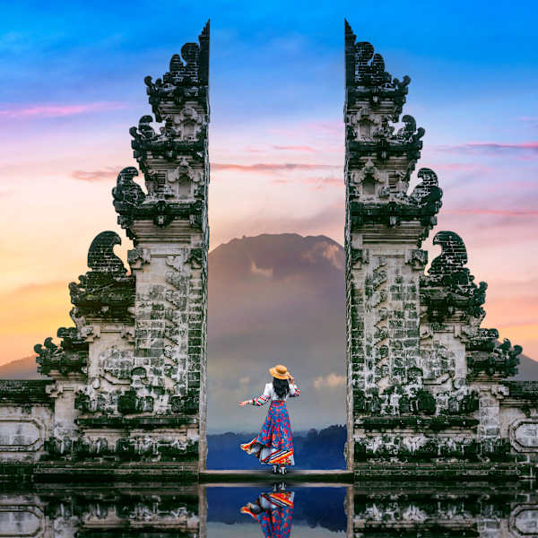 Junge Frau steht in Tempeltoren des Lempuyang Luhur Tempels auf Bali, Indonesien. © tawatchaiprakobkit via Getty Images