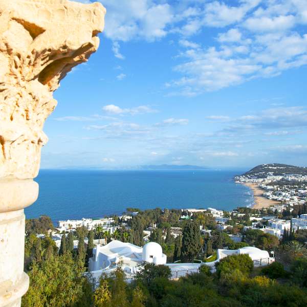 Blick an einer Säule vorbei auf eine Stadt am Meer