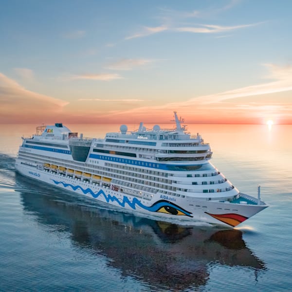 Ein Kreuzfahrtschiff auf See bei Sonnenuntergang.